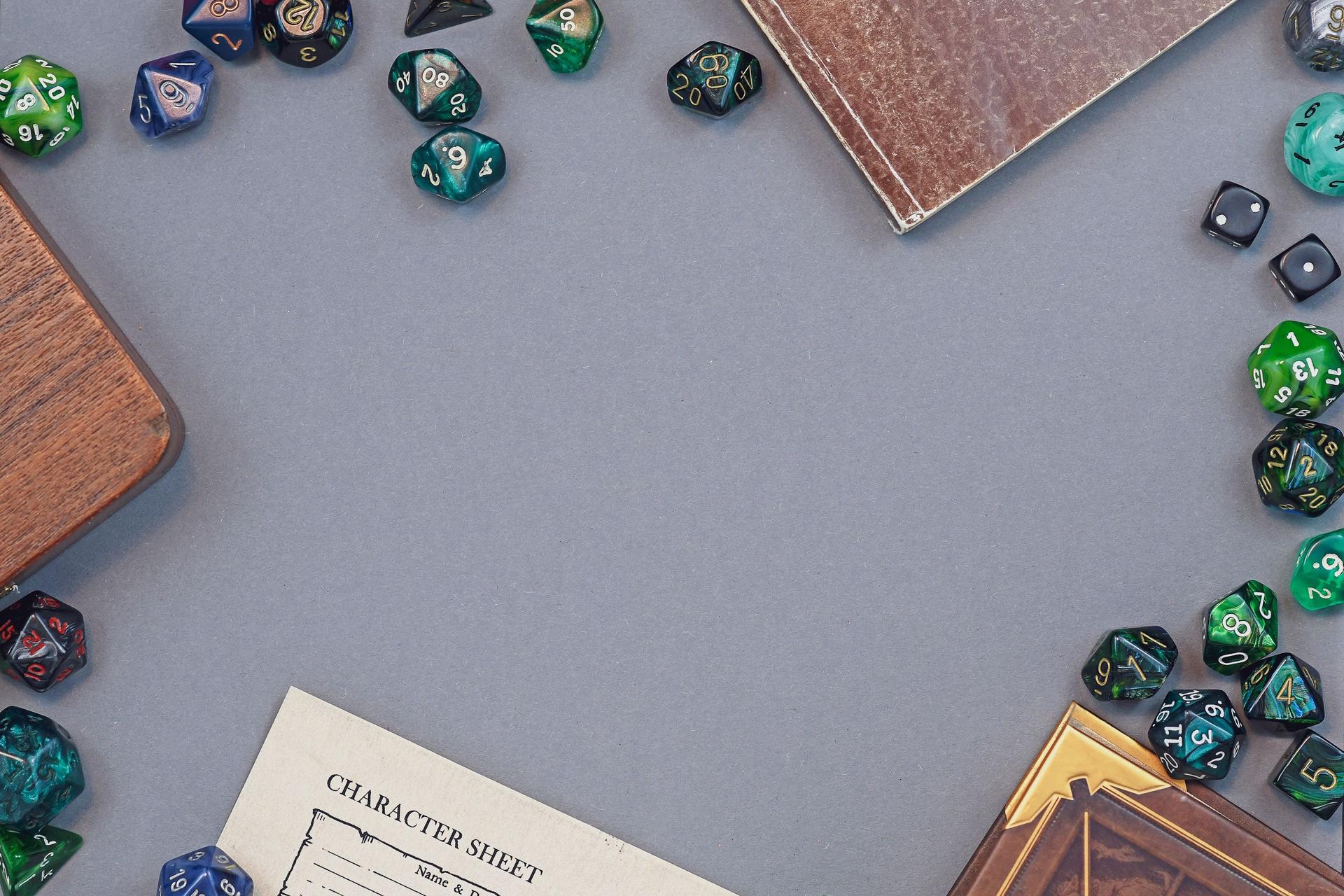Flat lay concept design for tabletop role playing with colorful green and blue dices, character sheet and rule books with empty copy space on gray background