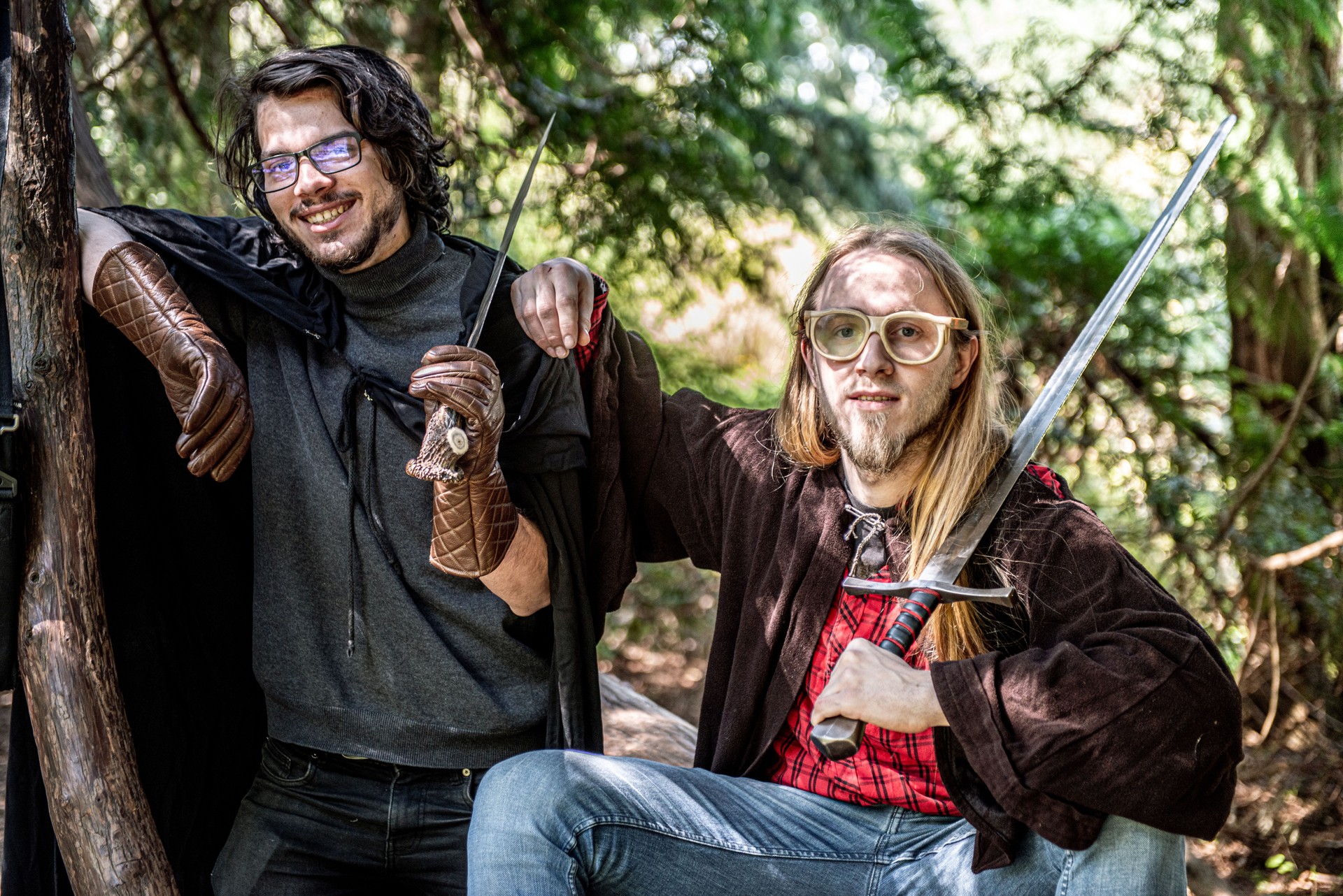 Friends posing as LARP Fantasy roles with robes and swards in the park